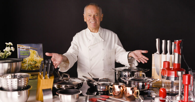 Chef Wolfgang Puck posing behind his products
